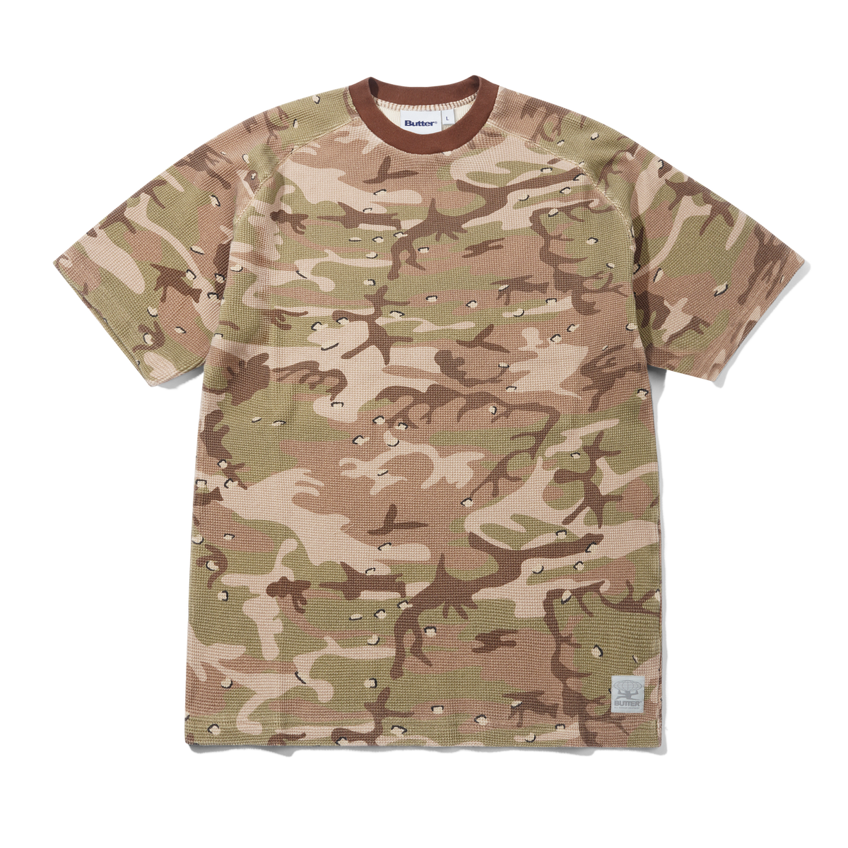 A short-sleeve crewneck t-shirt featuring a desert camouflage pattern in shades of tan, beige, and brown. The shirt has a distinctive waffle-weave texture and is shown flat against a solid white background.
