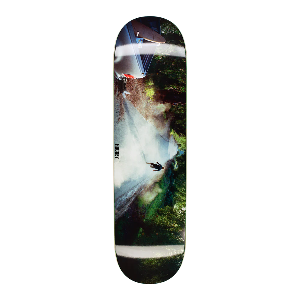 A skateboard deck featuring a photographic art print of a waterfall and forest, shown vertically against a plain white background.