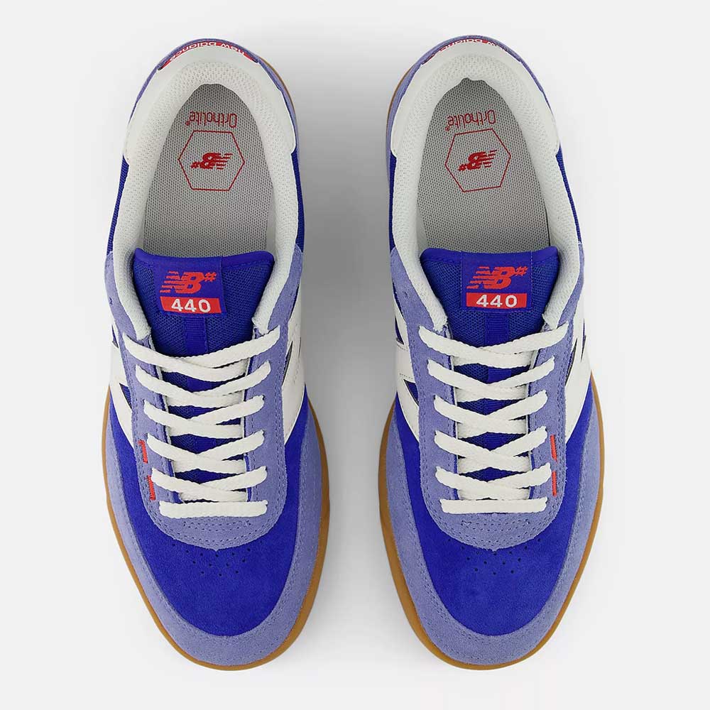 Pair of blue sneakers with white laces on a white background