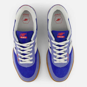 Pair of blue sneakers with white laces on a white background