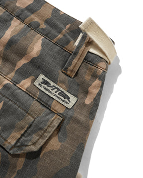 Close-up of camouflage pants showing a front flap pocket, belt loop, waistband, and a sewn-on brand patch that reads RITTER All Terrain Apparel.
