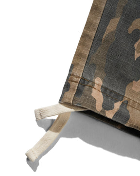 Camouflage-patterned fabric with a white strap on a light gray background
