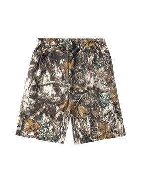 A pair of camouflage shorts featuring a realistic woodland tree branch and leaf pattern in shades of brown, beige, green, and gray, shown against a plain white background.