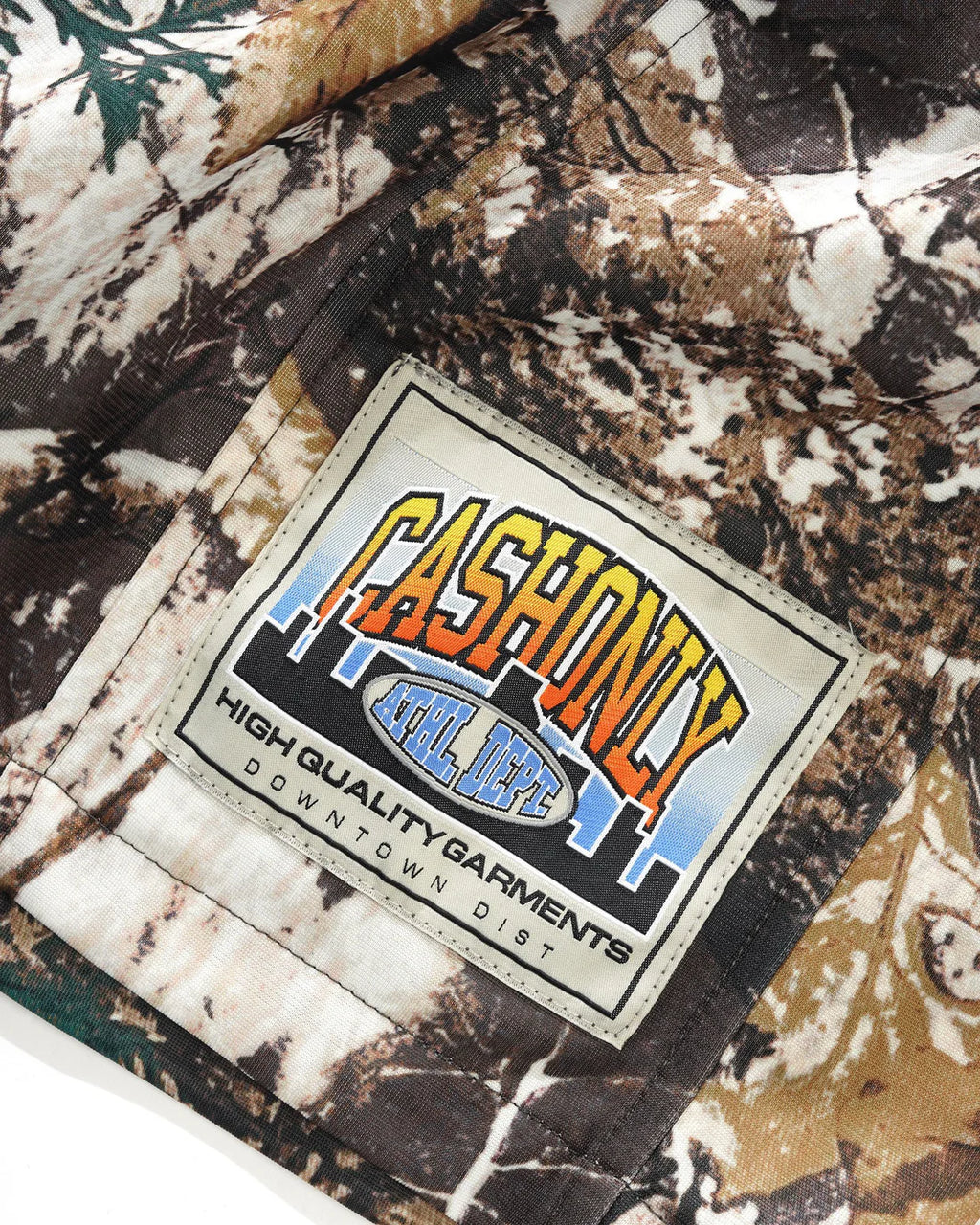 Close-up of a camouflage-patterned fabric with a 'Cashonly' label.