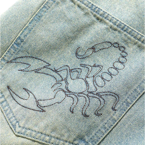 Embroidered scorpion design on denim fabric