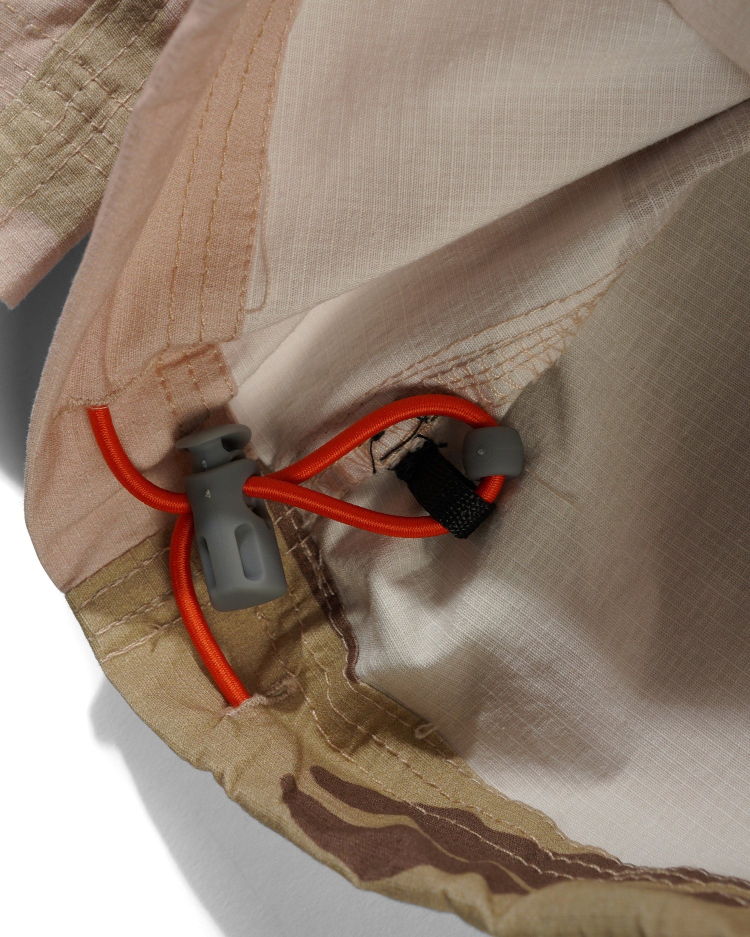 Close-up of a beige tent with red and black zipper pullers on a white background