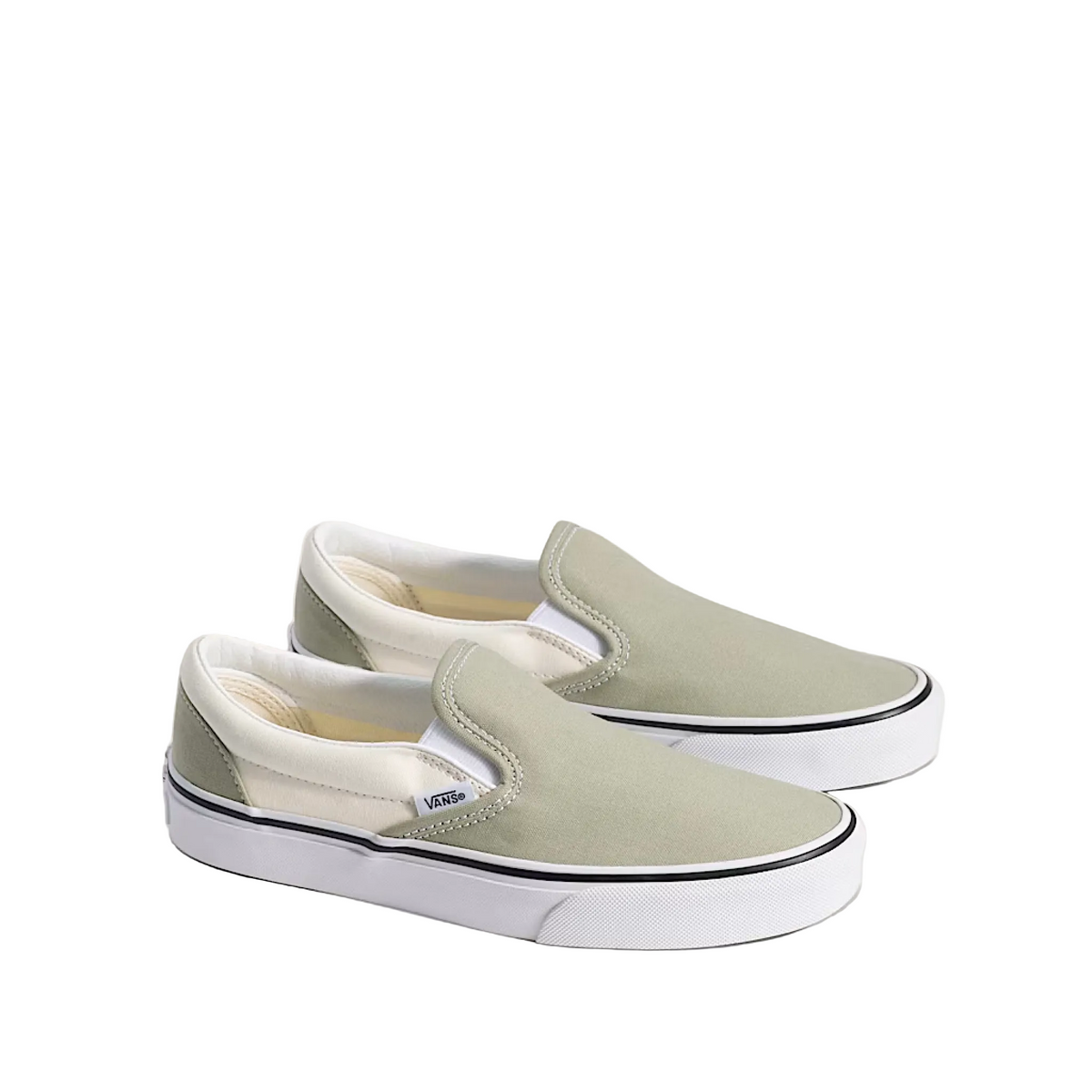 Pair of light gray slip-on sneakers with white soles on a beige background