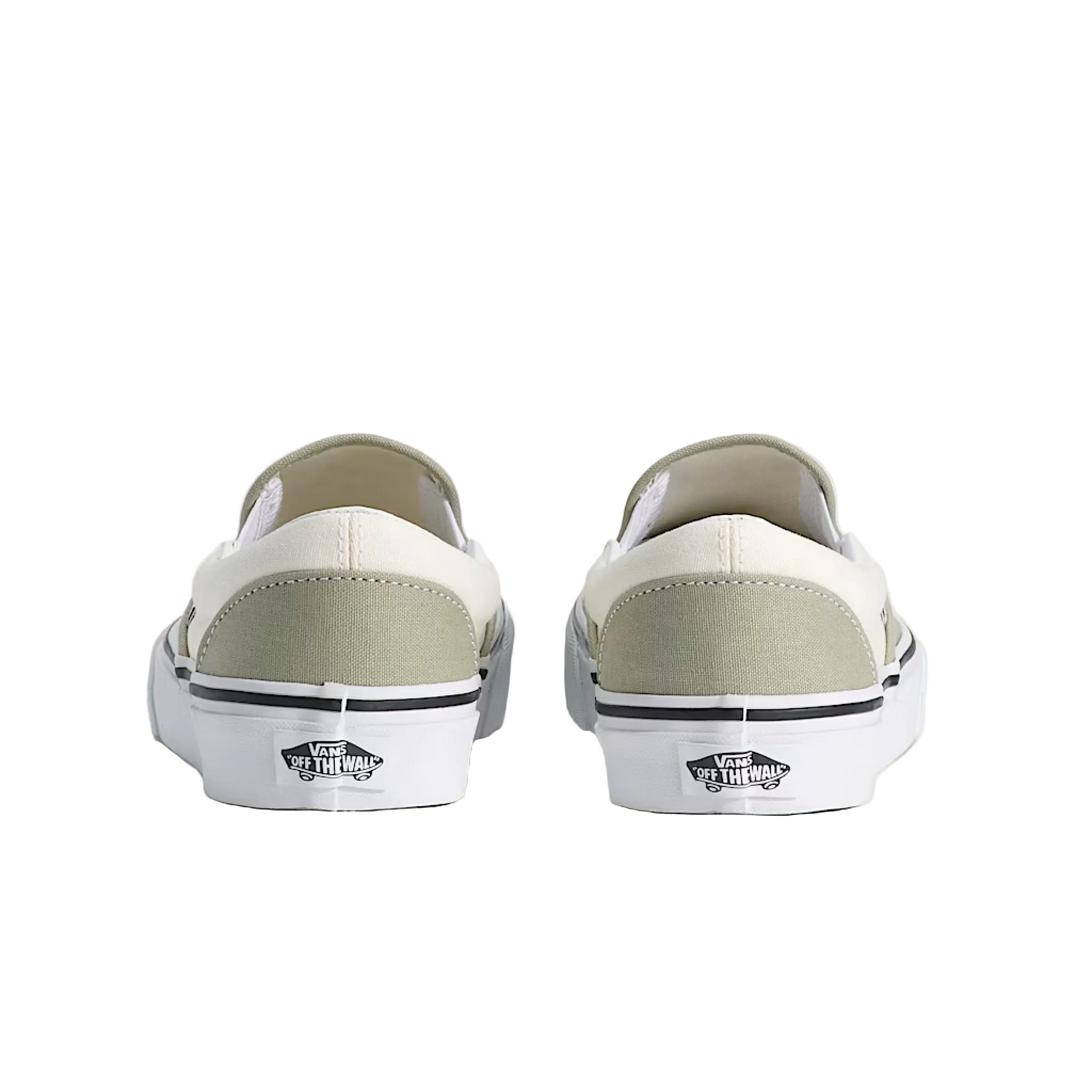 Pair of white slip-on sneakers with gray soles on a light beige background