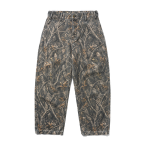 A pair of camouflage pants with a realistic woodland tree branch and leaf pattern in shades of gray, brown, and beige, shown flat against a solid white background.