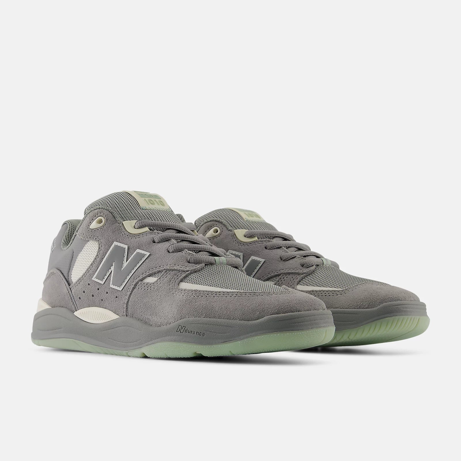Gray sneakers with green accents on a white background