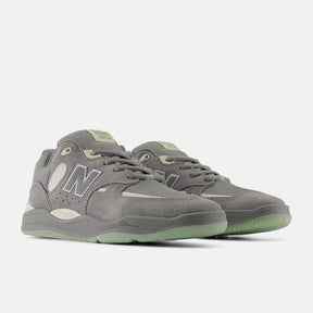 Gray sneakers with green accents on a white background
